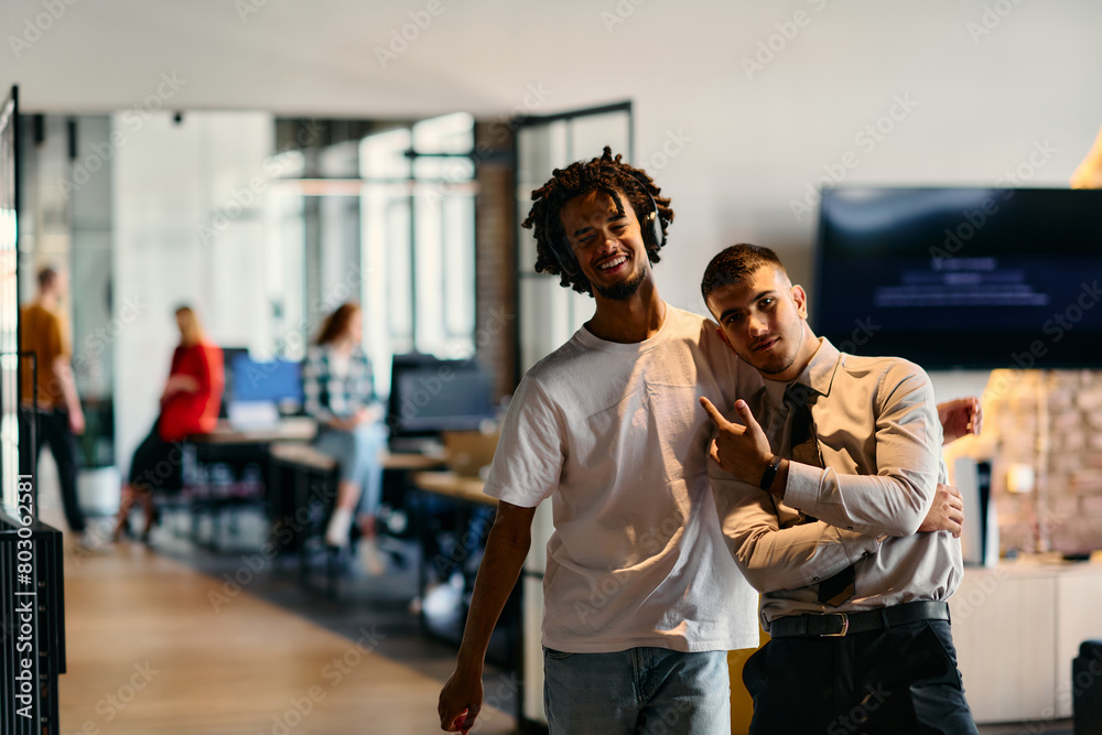 A group of colleagues, including an African American businessman and a young leader in a shirt and tie, pose together in a modern coworking center office, representing a dynamic blend of