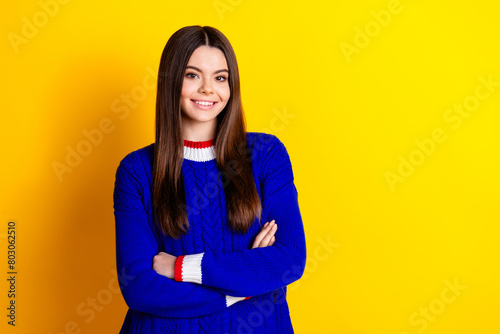 Photo portrait of pretty teen girl crossed hands confident wear trendy knitwear blue outfit isolated on yellow color background © deagreez