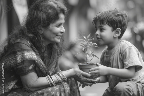 A little boy giving his mother a potted plant that they grew together, now blossoming just like their relationship, photo