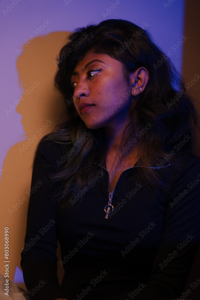 A woman with long hair is sitting in a dark room A woman with long hair is sitting in a dark room