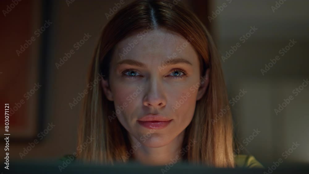 Portrait serious woman looking camera sitting dark home. Girl feeling tired 