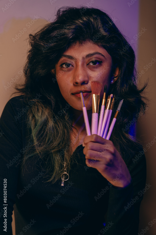 Fototapeta premium A woman is holding a brush set in her hand