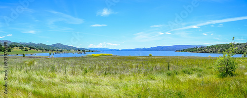 panoramic landscape with lake green grass blue sky 