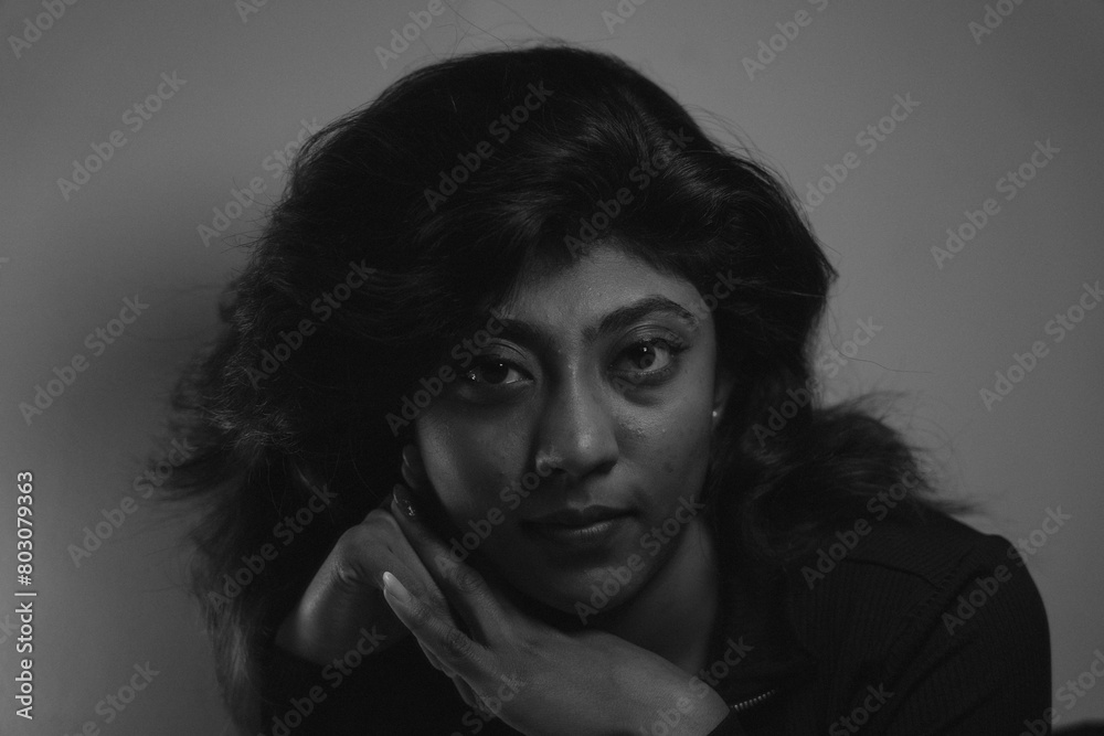 A woman with long hair is sitting on the ground and looking at the camera A woman with long hair is sitting on the ground and looking at the camera