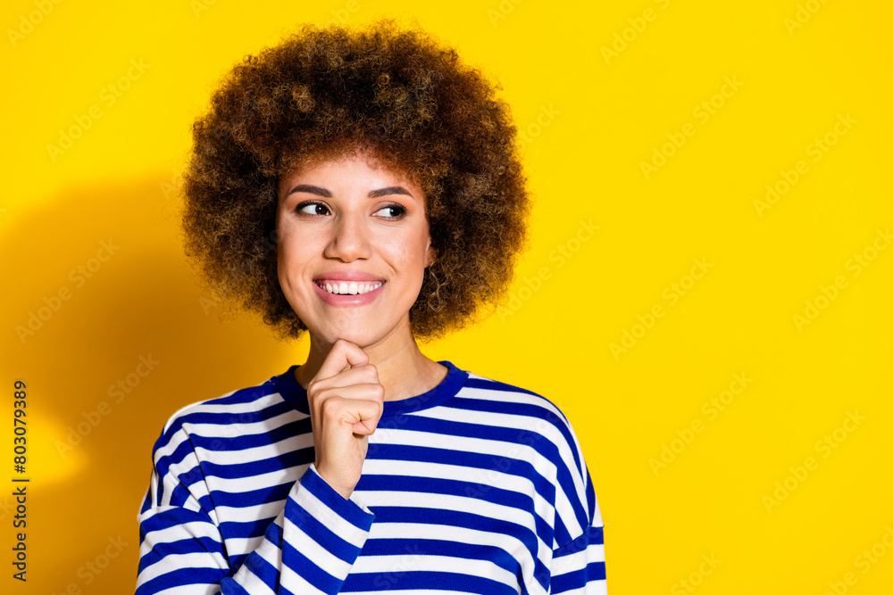 Photo of nice young girl look empty space think wear striped shirt isolated on yellow color background Photo of nice young girl look empty space think wear striped shirt isolated on yellow color background