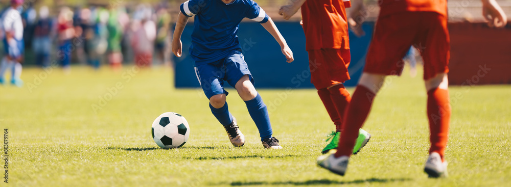 School soccer league. Kids in red and blue soccer shirts play competition match during youth football tournament School soccer league. Kids in red and blue soccer shirts play competition match during youth football tournament