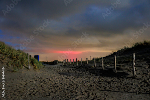 Dunes on the beach near the Pettendorf Monument in the Netherlands at night with a full moon