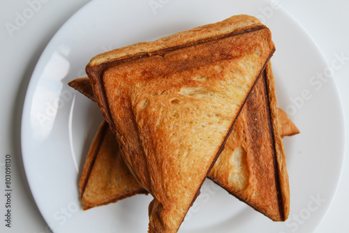 Some toasts or toasted breads, on white plate, isolated on white background, flat lay or top view