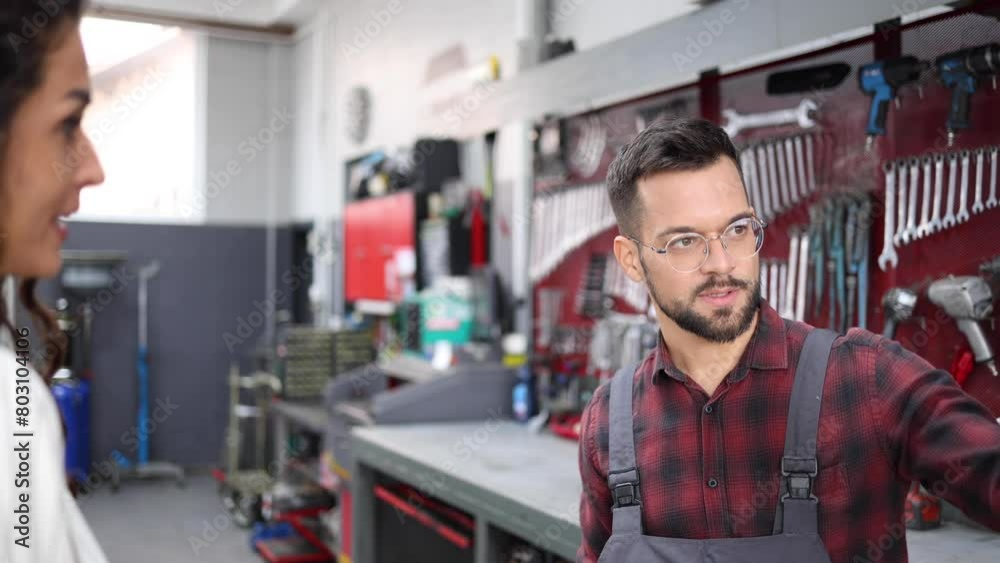 Auto mechanic talking with a woman whose car got broken Auto mechanic talking with a woman whose car got broken