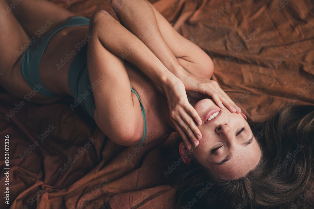 Obraz premium Closeup photo of gorgeous stunning young lady in seductive underwear touch cheeks applying lotion isolated on brown color background