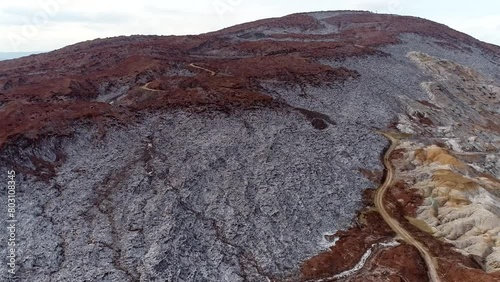 A dirt road between the big salt mountain and the salt water lake in the valley High resolution and quality aerial footage. photo