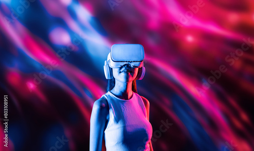 Smart female standing surrounded by neon light wearing VR headset connecting metaverse, future cyberspace community technology. Elegant woman looking faraway and smiling satisfactorily. Hallucination. © Summit Art Creations