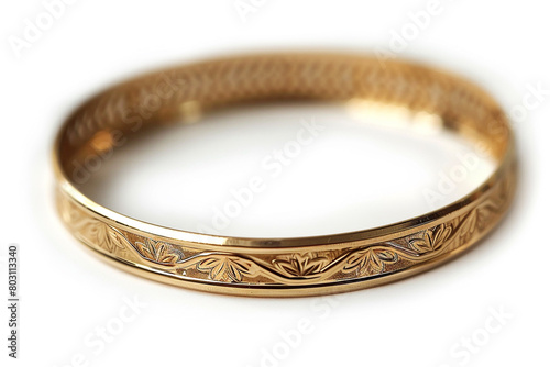 A sleek gold bangle, engraved with delicate patterns that catch the eye.