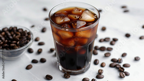 Glass of tasty cold brew and coffee beans on white background