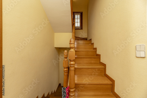 Interior stairs of a single-family home with oak wood balustrades with wooden handrails and steps of the same material