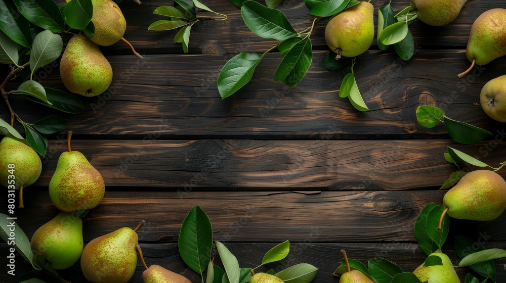 Fresh ripe pears with leaves scattered on a dark wooden table, creating a natural pattern.
