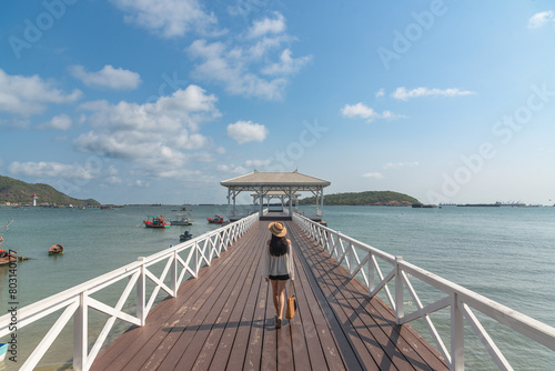 Lonely woman stand alone on the white bridge into the sea at Koh Sichang as landmark at Thailand