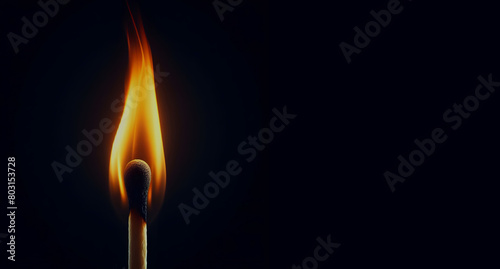 burning match stick on black background