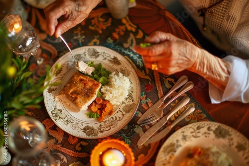 A sophisticated senior woman enjoys a healthy dinner of salmon, rice, and carrots at a beautifully decorated table, illuminated by candlelight.