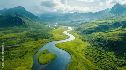 A river flows through a lush green valley with mountains in the background. The scene is serene and peaceful, with the water reflecting the surrounding landscape photo