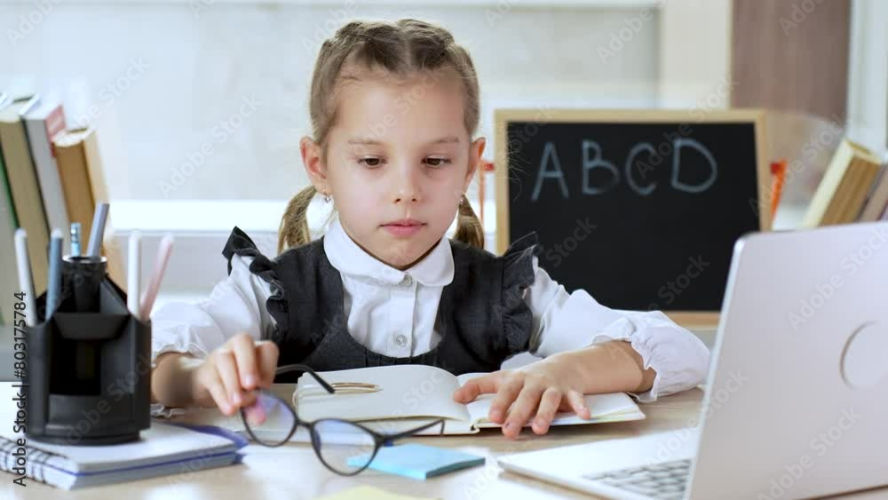 A tired school girl takes off her glasses after a long learning. A tired school girl takes off her glasses after a long learning.