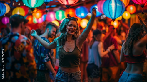 Young people dancing at a party under the bright lights of lanterns