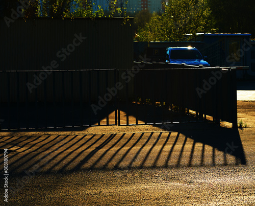 Dramatic fence shadow falling on the road backdrop photo