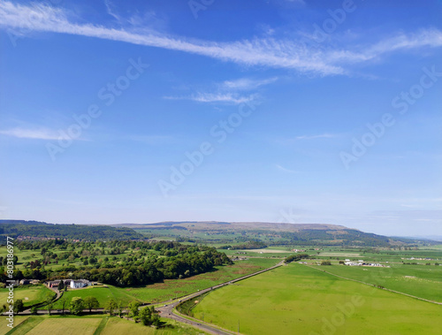 Lawn and mountains in the wild fields of Stirling, Scotland, UK, with blue sky and white clouds