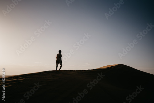 silhouette of a person walking on the sand