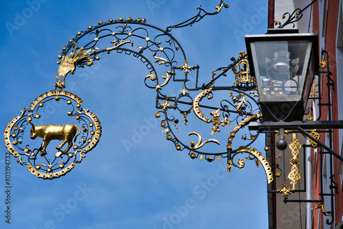 typical decorative wrought iron sign of a bull against the background of a blue sky. Isny, Germany. photo