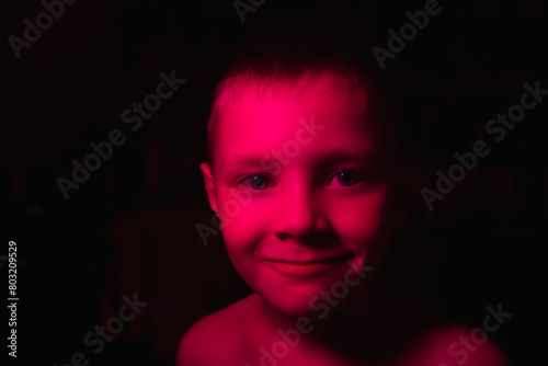 Portrait of a boy in the dark with red backlight
