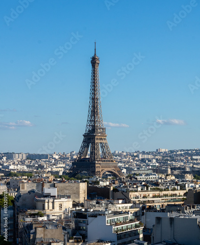 Panoramic view of the Eiffel tower, on the Parisian buildings in the center, Arc de Triomphe de l'Étoile, located on the Charles de Gaulle square, and at the western end of the Champs Elysées avenue 