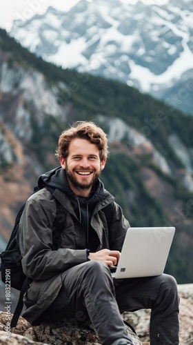 Happy male freelancer working on laptop in mountain wilderness © Veronika