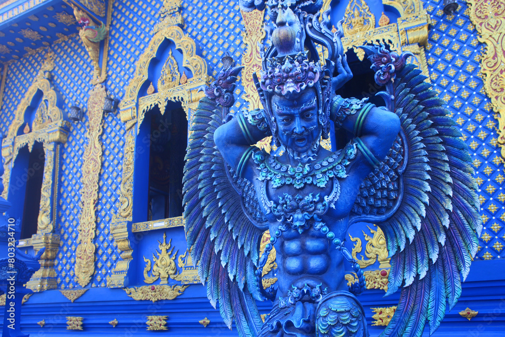 Fototapeta premium A mythological winged warrior at the entrance to the modern Wat Rong Sueaten temple, also known as Blue Temple, Chang Rai, Thailand