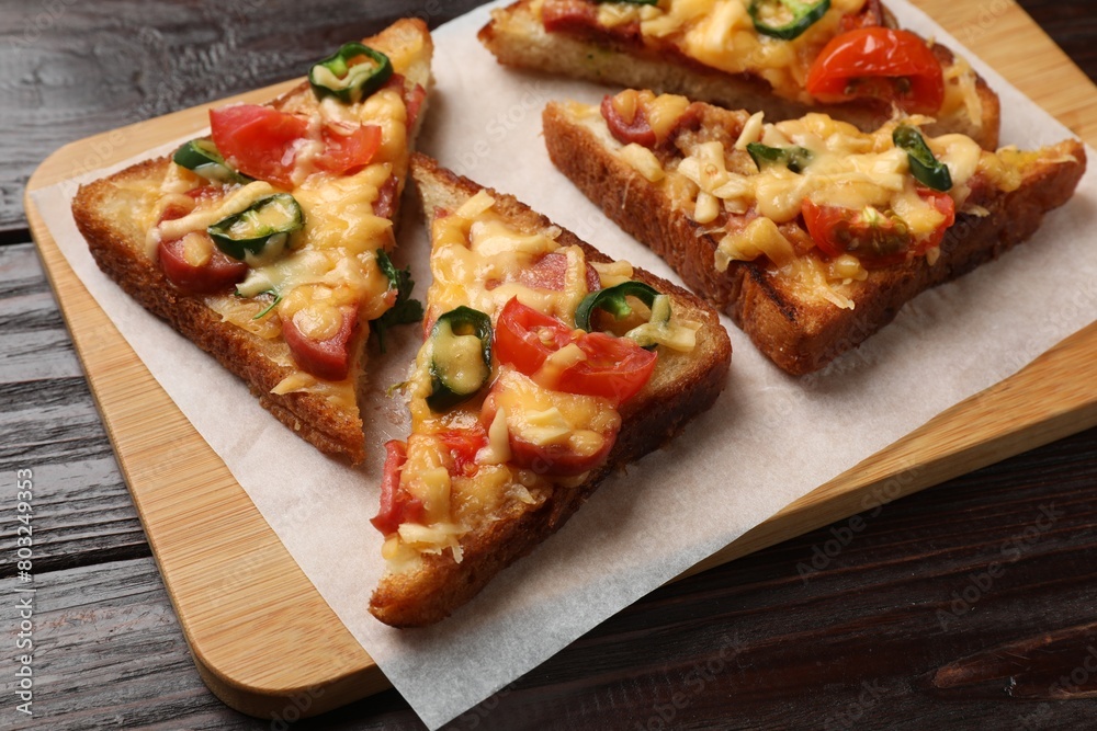 Tasty pizza toasts served on wooden table, closeup