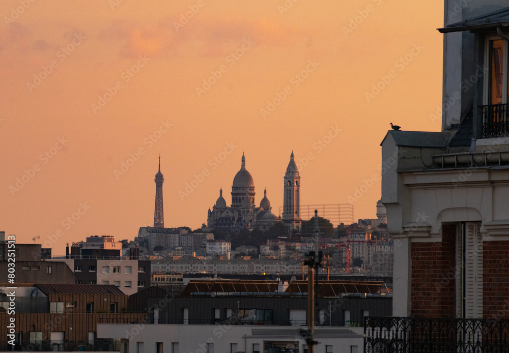 sunset over the rooftops of paris with views of the Eiffel Tower, The Sacré-Cœur is a basilica on top of Montmartre hill , Paris, France