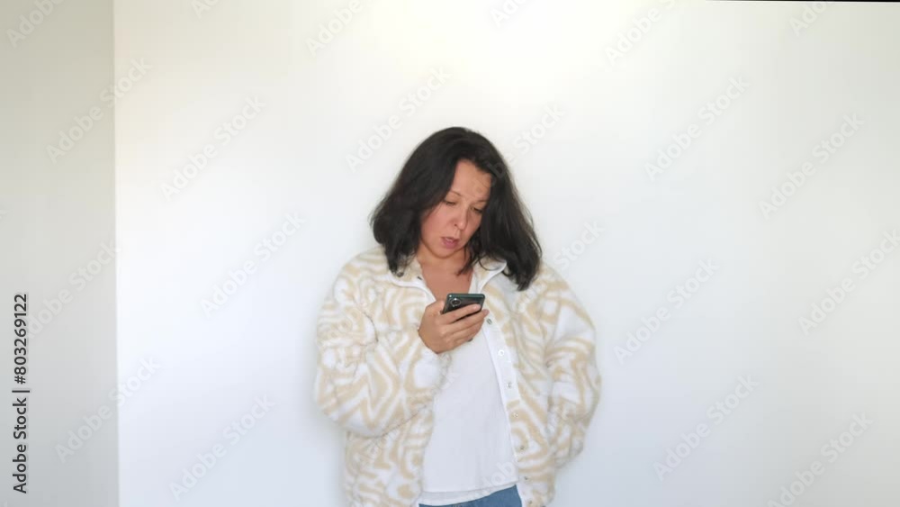 Concentrated and connected, a woman checks her phone, demonstrating the continuous blend of online interaction in daily routines. Concentrated and connected, a woman checks her phone, demonstrating the continuous blend of online interaction in daily routines.