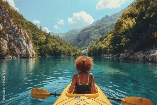 Woman Sitting in a Yellow Kayak on a River © denklim