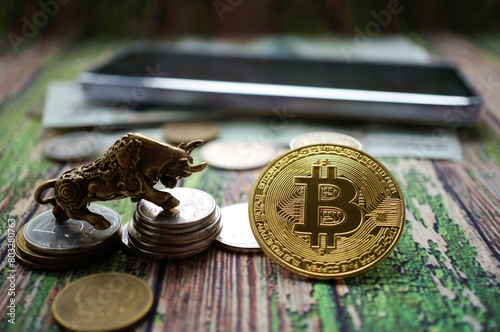 Wallpaper Mural A metal bull figurine with coins on the table. Bitcoin is nearby. Finance and economics. Torontodigital.ca