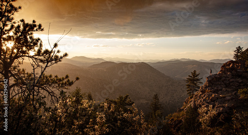 Wallpaper Mural Mountain vista during rain shower with warm late afternoon light streaking through.  Man overlooks the vista on edge of rock out cropping.  Torontodigital.ca