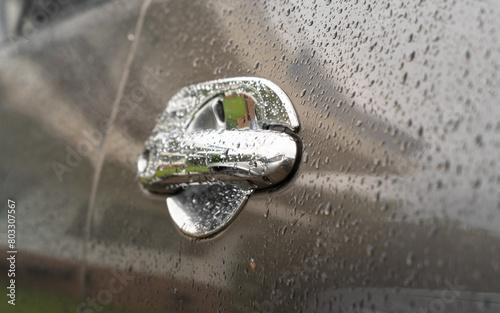 Car in parking with water drop rainy, foggy autumn day. Focus on car handle. Concept of safety driving problem.