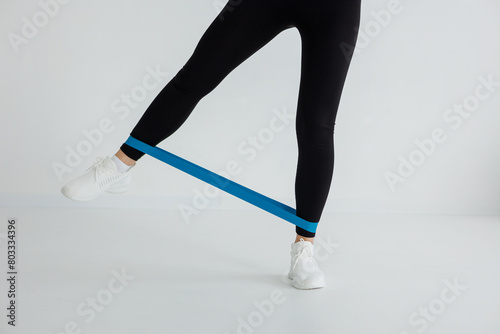 The person is wearing a blue resistance band on their leg, which is a common equipment used in sports like ice hockey. It helps strengthen the muscles around the knee and foot
