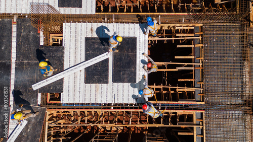 Men from the construction industry, working on the work of a building under construction. Placing slab pieces made with steel and concrete.