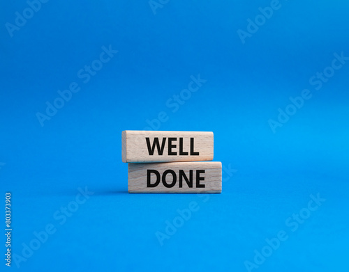 Well done symbol. Wooden blocks with words Well done. Beautiful blue background. Business and Well done concept. Copy space.