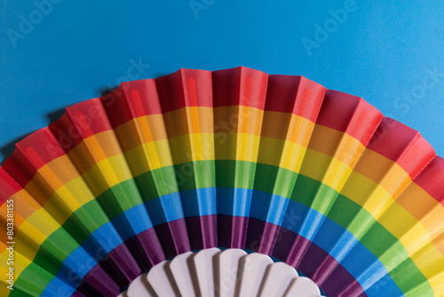 Beautiful multicolored fan on a blue background, heat, texture, colors