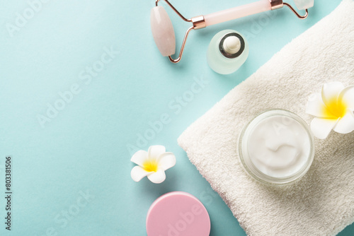 Skin care products on blue. Face cream, tonic, serum bottle. Flat lay image with copy space.