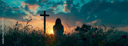 Divine Reflection: Woman Praying Silhouetted by Cross at Sunset photo