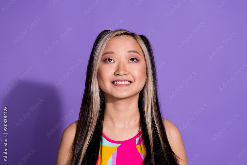 Photo of cheerful adorable nice girl wear stylish clothes look up empty space isolated on purple color background Photo of cheerful adorable nice girl wear stylish clothes look up empty space isolated on purple color background