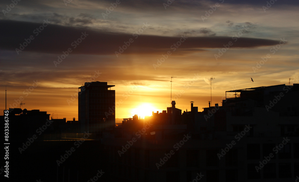 Colorful sunset skyline over silhouette city at dusk