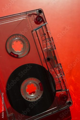 Audio cassette on a blurred red background.